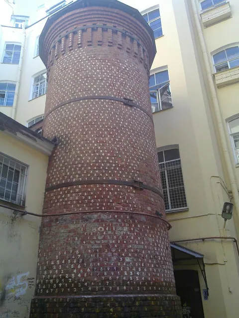 หอคอยกริฟฟิน (Griffin Tower) ทรงกระบอกสีแดงอิฐที่ประดับด้วยตัวเลขสีขาวเรียงเป็นแถวตั้งอยู่ระหว่างอาคารสีครีม