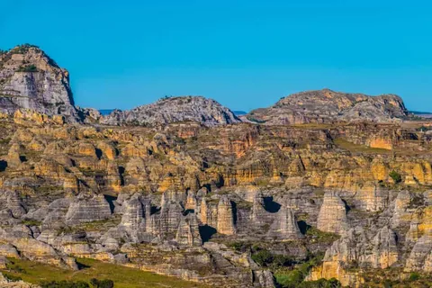 ทิวทัศน์ภูเขาหินสีเทาและเหลืองในอุทยานแห่งชาติอิซาโล่ (Isalo National Park) ใต้ท้องฟ้าสีฟ้าสดใส