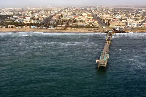 ภาพมุมสูงของเมืองสวาคอปมุนต์ (Swakopmund) ที่มีท่าเรือยาวทอดตัวลงไปในทะเลสีน้ำเงินเข้ม