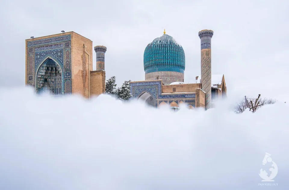 Gur-e-Amir Mausoleum สถาปัตยกรรมที่มีโดมสีฟ้าและหอคอยประดับลายกระเบื้อง ตั้งอยู่ท่ามกลางเมฆหมอกหนา