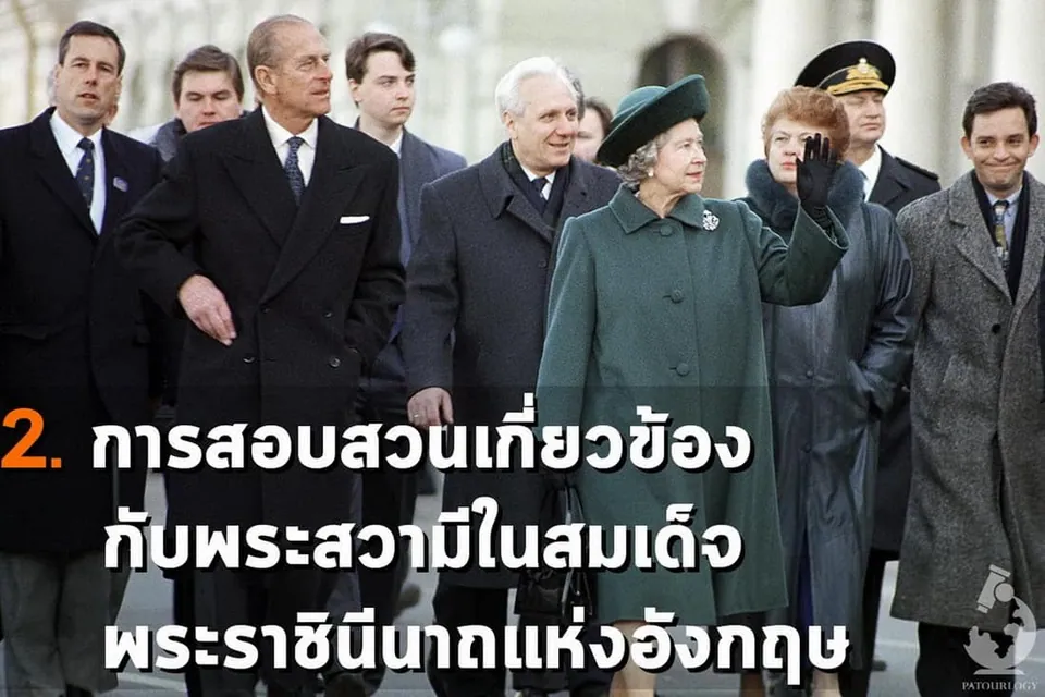 กลุ่มคนในชุดสูทและโค้ทยืนเรียงแถวกัน โดยมีผู้หญิงในชุดสีเขียวเข้มและหมวกดำยกมือขึ้นทักทายอยู่ด้านหน้า