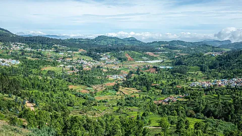 ทิวทัศน์ภูเขาสูงของเมืองอูตี (Ooty) ที่เต็มไปด้วยทุ่งนาสีเขียวและหมู่บ้านกระจายตัวอยู่ท่ามกลางป่าไม้
