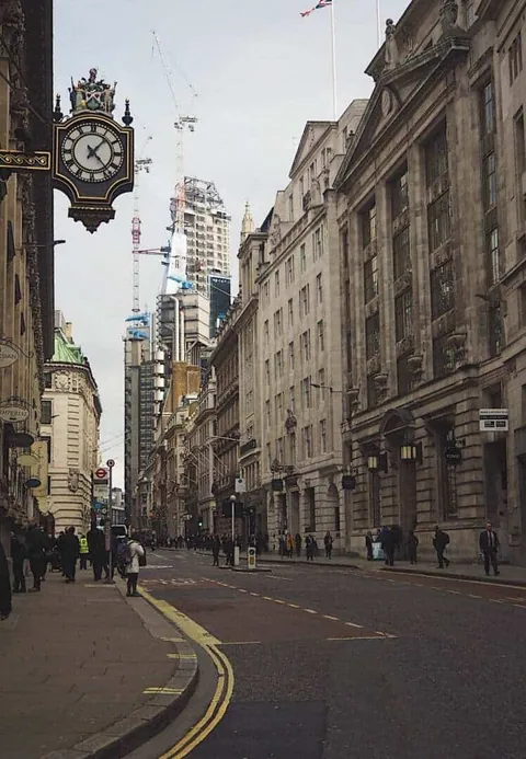 ถนนคอร์นฮิลล์ (Cornhill Street) มีอาคารสูงเรียงรายสองฝั่ง มีนาฬิกาแขวนขนาดใหญ่บนเสา และผู้คนเดินอยู่บนทางเท้า