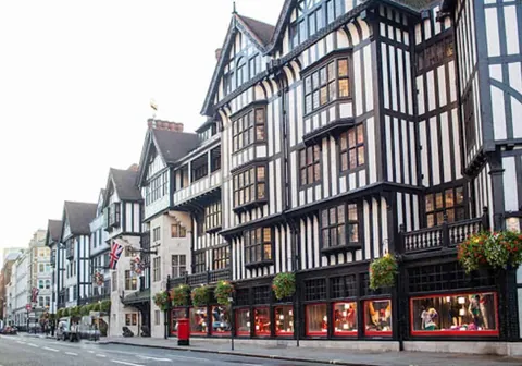 อาคารสไตล์ทิมเบอร์เฟรมสีขาวดำเรียงรายริมถนน เกรทมาร์ลโบโรห์ (Great Marlborough Street) มีหน้าต่างชั้นล่างสีแดงและธงสหราชอาณาจักร