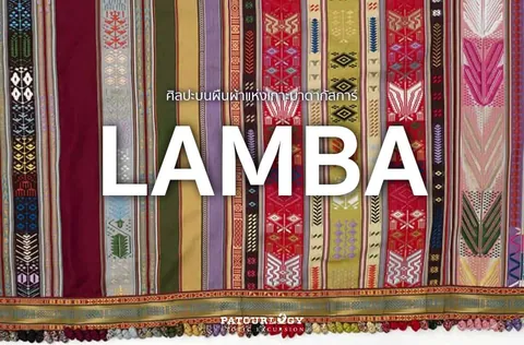 ผ้าทอลายเส้นแนวตั้งหลายสีจัดวางเรียงกัน มีตัวอักษร LAMBA ขนาดใหญ่สีขาวอยู่ตรงกลางภาพ