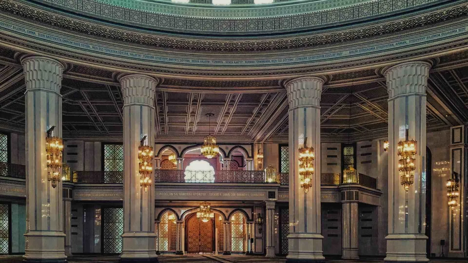 ภายในอาคารที่มีเพดานโค้งประดับลวดลาย มีเสาหินสีขาวขนาดใหญ่เรียงราย และโคมไฟระย้าแขวนอยู่